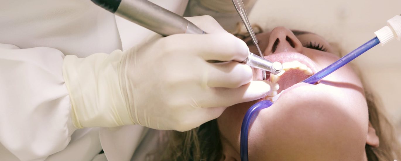 dentist working working on woman s teeth