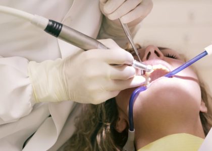 dentist working working on woman s teeth