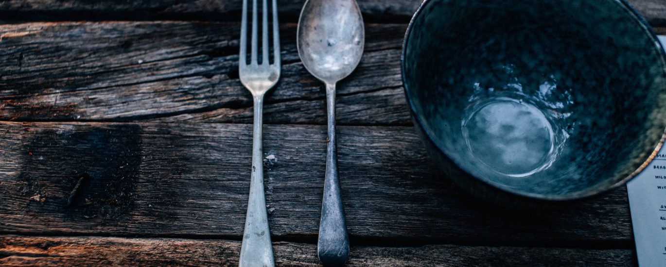 metal bowl near cutlery on rustic table